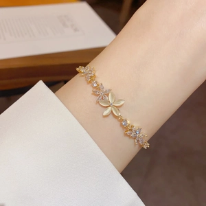 Detail of gold flower bracelet with cat eye stone and sparkling zircon on wrist