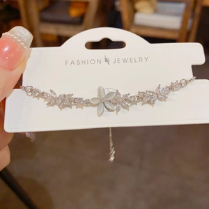 Detailed close-up of zircon flower bracelet with cat eye stone petals on display card