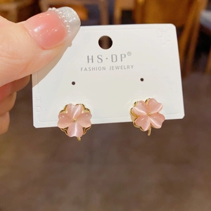 Detail of pink cat-eye stone clover earrings on a white jewelry display card