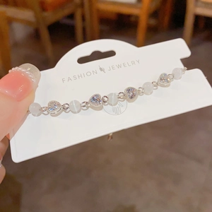 Elegant cat eye stone and heart zircon beaded bracelet on a white jewelry card