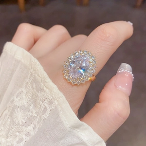 Gros plan détaillé d'une bague de luxe en or avec pierre ovale et sertissage halo