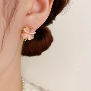 Elegant pink cat eye stone four-leaf clover stud earrings with golden finish on ear