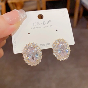 Détail macro de boucles d'oreilles ovales en zircon rose avec tige en argent S925