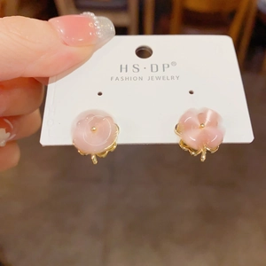 Detailed view of pink cat eye stone clover stud earrings on a white jewelry card