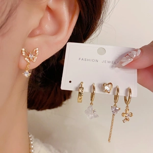 Goldenes Schmetterling- und Herz-Ohrring-Set mit Kristallen an einem Model getragen