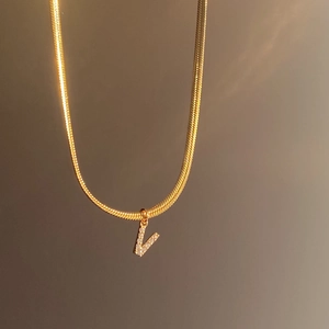 Elegant 18k gold plated snake chain necklace with a sparkling V-letter zircon pendant