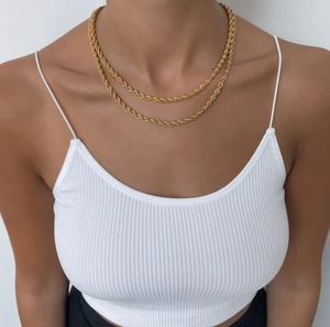 Dettaglio di collana a corda da 5mm placcata in oro 18k con trama intrecciata su modella