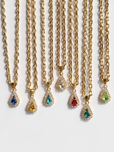 Detail of 18k gold plated teardrop pendants in seven vibrant colors on chunky link chains
