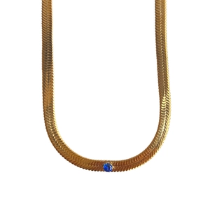 Detail der 18k vergoldeten Schlangenkette mit einem zentralen blauen Zirkonia-Stein