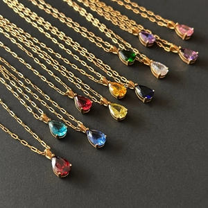 Close-up of colorful pear-cut birthstone necklaces with 18k gold plated chains