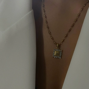 Detail van 18K vergulde ketting met sprankelende diamanten vierkante letter K hanger