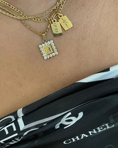 Detailopname van drielaagse gouden kettingen met H-hanger en gegraveerde plaatjes