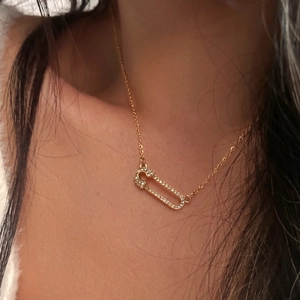 Close-up of 18k gold plated safety pin pendant necklace with shimmering zircon crystals