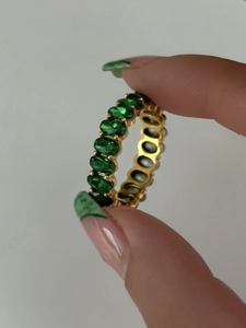 Detail of 18k gold plated eternity ring featuring oval green emerald cubic zirconia