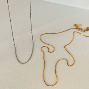 Detail of twisted snake chain necklaces in gold and silver finish with lobster clasp