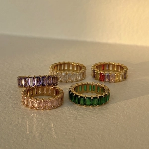 Detailed macro view of five 18k gold plated eternity rings with colorful zircon stones