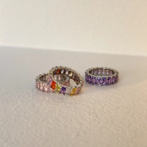 Detailed macro view of eternity bands with colorful rectangle-cut cubic zirconia stones