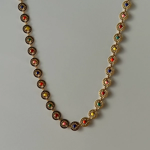 Detail van 18k vergulde zon tailleketting met kleurrijke dubbelzijdige inlays