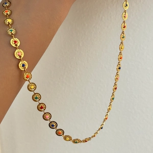 Detailopname van 18k vergulde zonketting met kleurrijke geëmailleerde bloemschijven