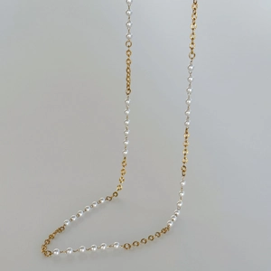 Macro detail of the 18k gold plated chain with textured links and small white pearls