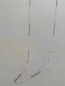 Detail of vintage textured waist chain with 18k gold plating and white pearls