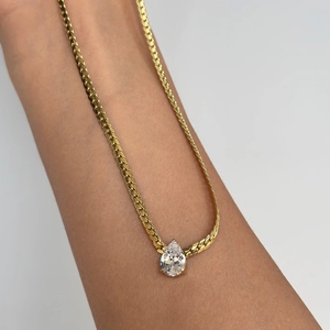 Elegant gold teardrop zircon pendant on snake bone chain necklace worn on the arm