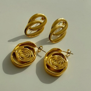 Dettaglio macro di orecchini vintage a doppio cerchio e spirale placcati oro 18k