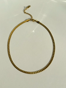 Detail of 18k gold plated herringbone chain with textured pattern and lobster clasp