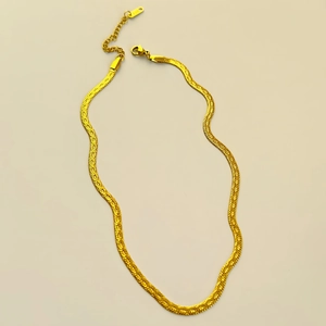Detail of 18k gold plated herringbone chain with adjustable lobster clasp and tag