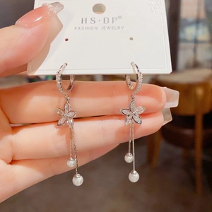 Detailed close-up of elegant silver flower drop earrings with zircon and long pearl tassels