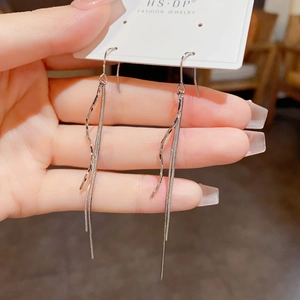 Detail van zilveren golvende lange kwastjes oorbellen op een sieraden displaykaart