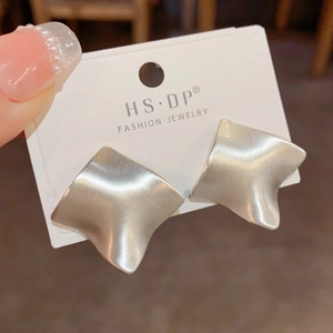 Macro shot of silver square stud earrings with brushed texture on jewelry card