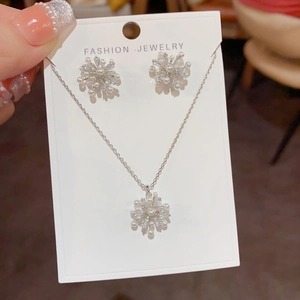 Detailaufnahme des Schmucksets mit Schneeflocken-Perlenkette und passenden Ohrringen