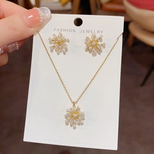 Nahaufnahme von Gold-Blumenschmuckset mit weißen Perlen und Zirkon auf Karte