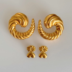 Macro detail of 18k gold plated spiral hoop earrings with heart shaped clasps