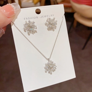 Nahaufnahme des Schneeflocken-Schmucksets mit weißen Perlen und funkelnden Zirkonia-Steinen