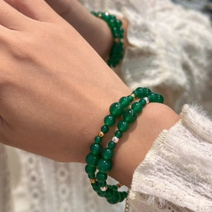 Detail view of double-layer green agate bead bracelet with metallic spacers on wrist