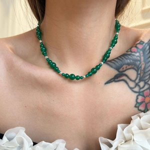 Close-up of green agate beads and silver spacers on a vintage style beaded necklace