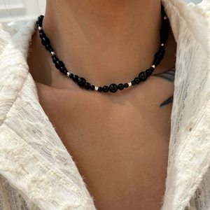 Close-up of black agate beaded necklace with silver spacer beads on a model's neck