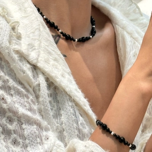 Vintage style black beaded agate necklace and bracelet set on a white lace background