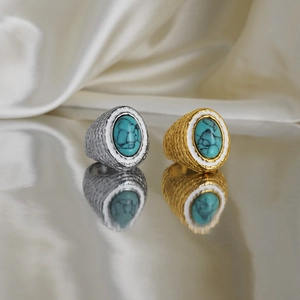 Close-up of vintage 18k gold plated turquoise rings with white enamel and floral engravings