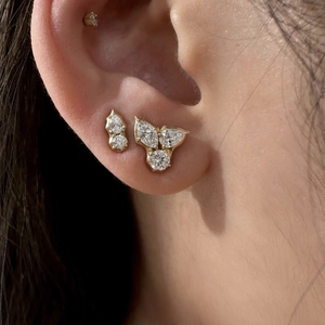 Close-up of gold plated titanium steel stud earring set with zircons on a woman's ear