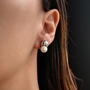 Chic Gothic pearl and silver titanium steel stud earring worn on model against black background