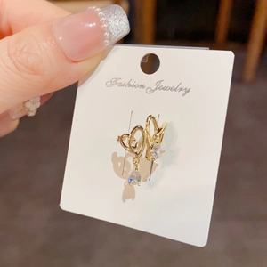 Golden heart-shaped ear clips with teardrop zircons on a white display card