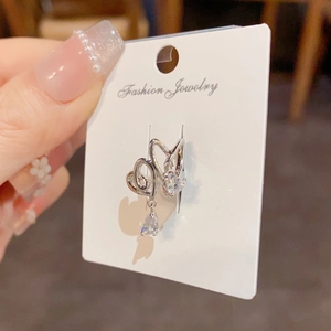 Silver heart earrings with water drop zircon dangling on a white fashion jewelry card