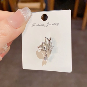 Close-up of silver ear cuff featuring double hollow hearts and zircon water drop pendant