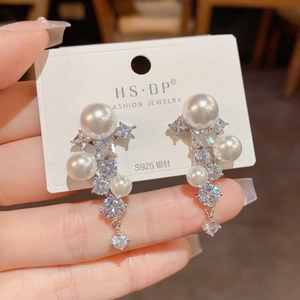 Détail de boucles d'oreilles de luxe en argent S925 avec glands en zircon et perles