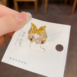 Detalle del anillo de mariposa chapado en oro con gemas amarillas y cristales finos