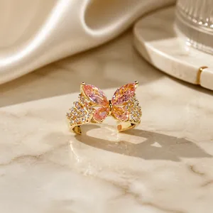 Detalle de un anillo de mariposa dorado con gemas rosas y cristales engastados en pavé