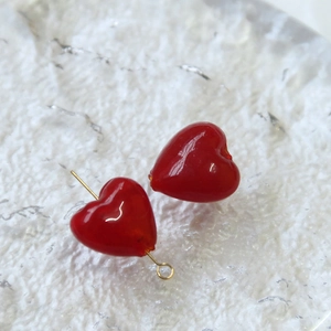 Vista macro di perle di vetro a cuore rosse semitrasparenti per la creazione di gioielli